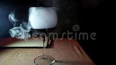干冰的效果，在酒吧的玻璃上翻腾，在罐子里吹出白色的浓烟，喝着一杯红酒